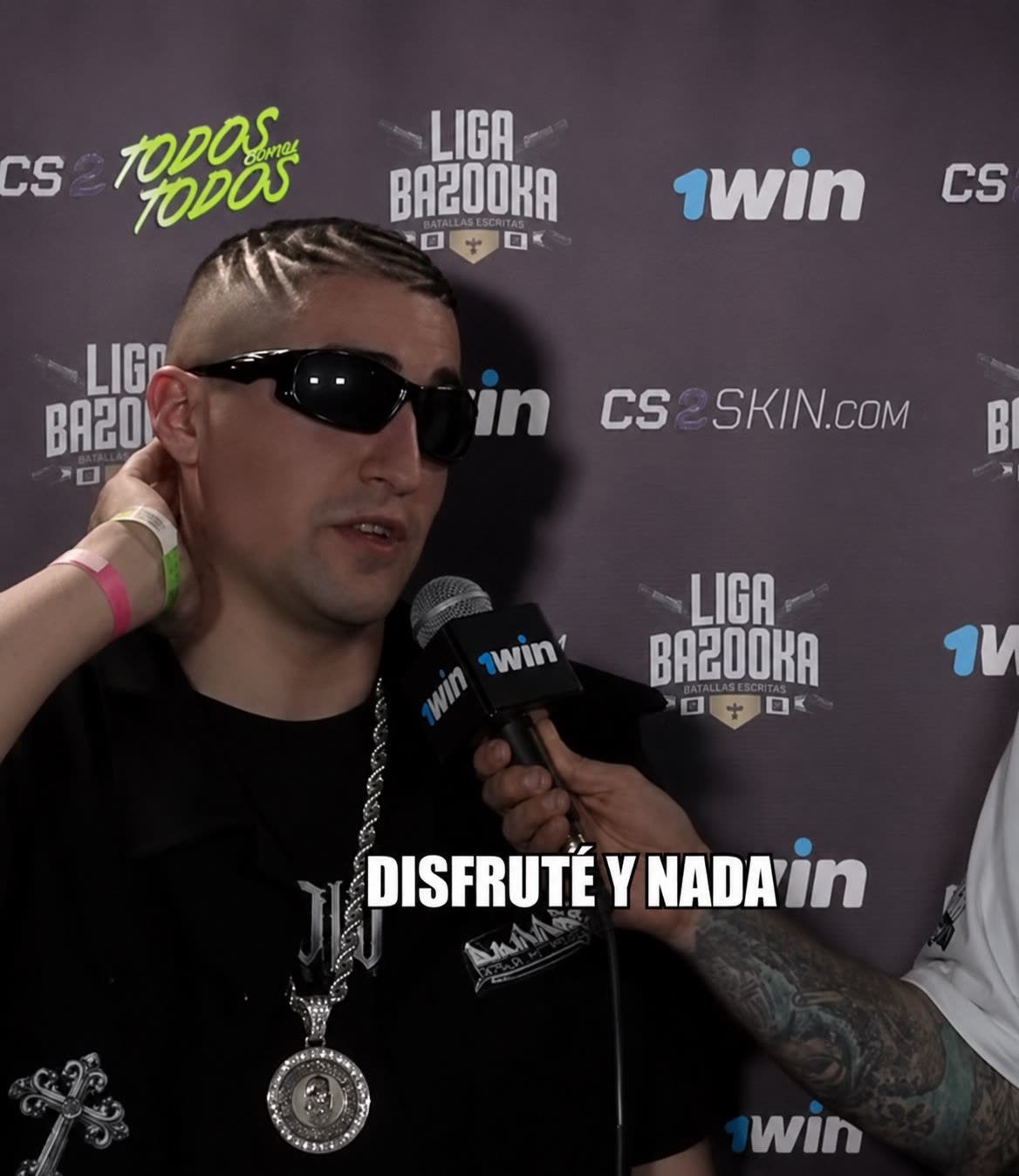 Micrófono de mano y backdrop de prensa con el logo de 1Win